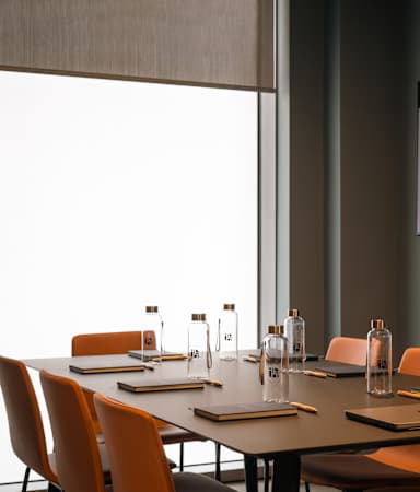 A conference room with a long table and chairs.