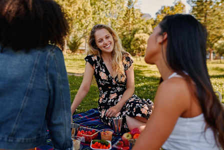 Three women having a picnic in a park.