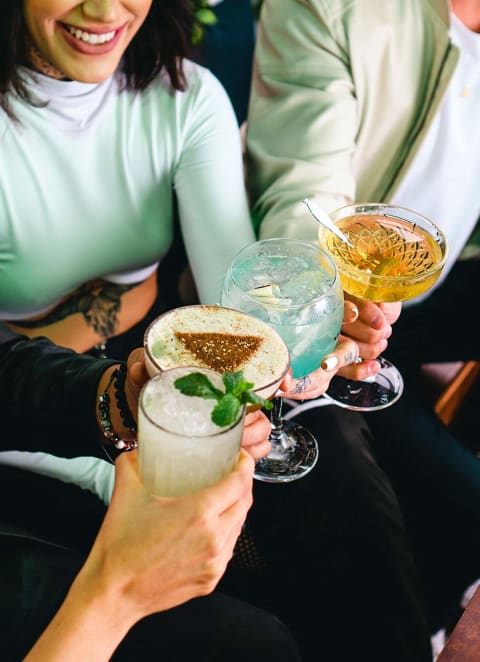 a group of people sitting around a table holding drinks