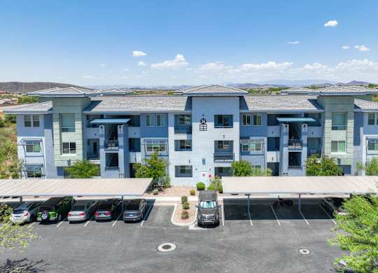 A parking lot in front of a building with a clear blue sky above.