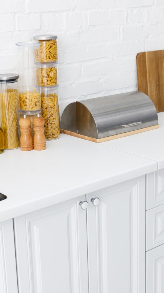 a kitchen with white cabinets and a stainless steel sink