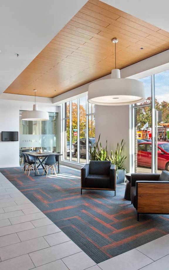 A modern interior with a red wall on the left and a wooden ceiling.