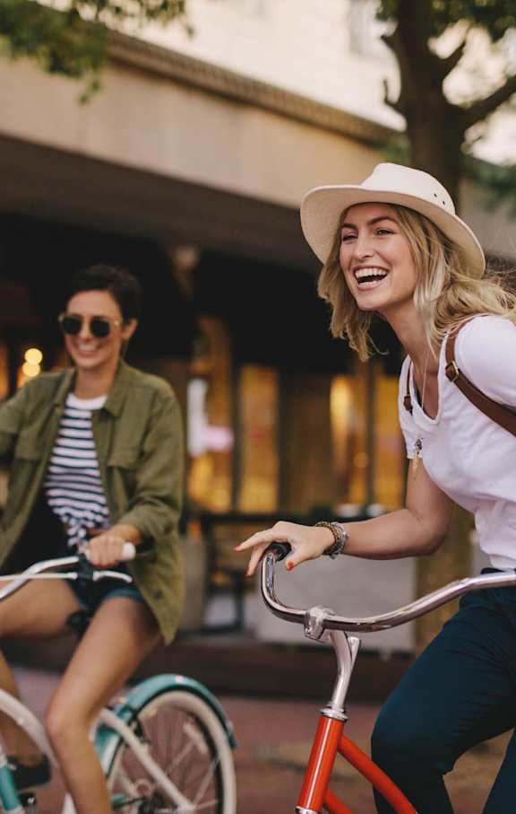 Two people riding bicycles in an urban setting.