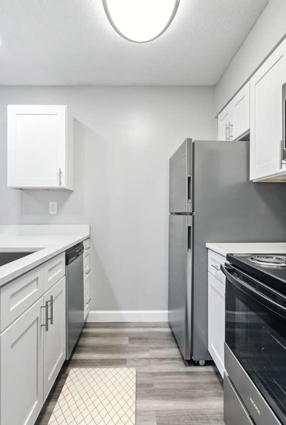 A modern kitchen with white cabinets and stainless steel appliances.at Hanna Village, Indianapolis Indiana