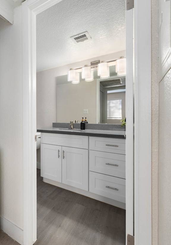 A white dishwasher is in a kitchen next to a white microwave.