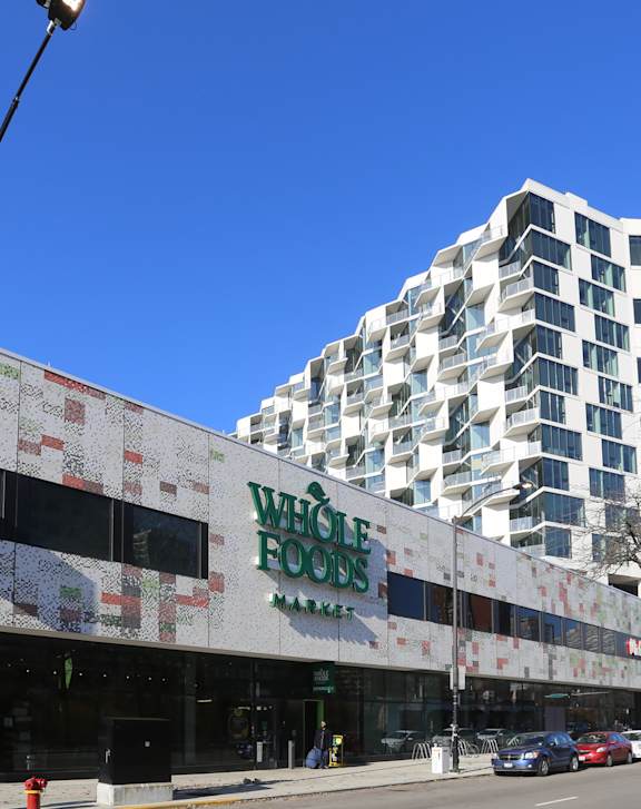A Whole Foods store is located in front of a modern building.