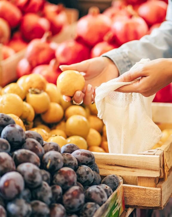 people buying fruit at an outdoor market