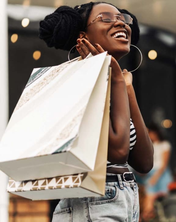 a woman holding shopping bags in a store