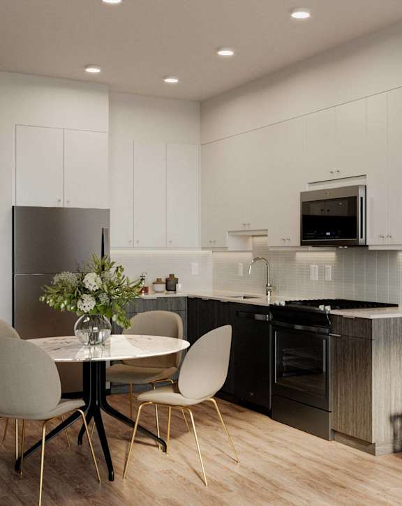 A modern kitchen with a dining table set for two.