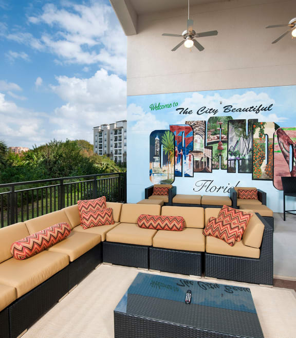 a patio with couches and a coffee table in front of a mural at The Rialto, Orlando, 32819