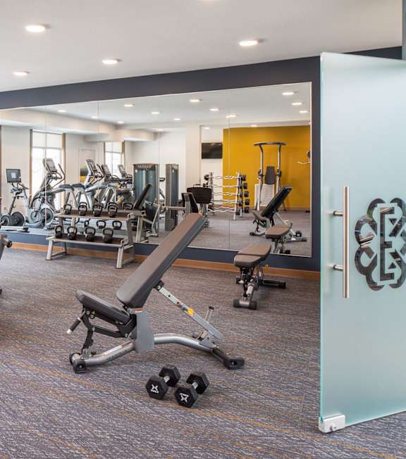 A gym with a variety of equipment including weights and cardio machines. at The Edison at Rice Creek I and II, Minnesota, 55126