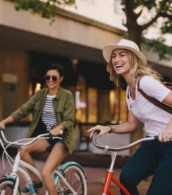Two people riding bicycles in an urban setting.