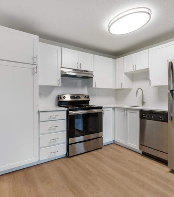 A kitchen with wooden cabinets and a stainless steel refrigerator.