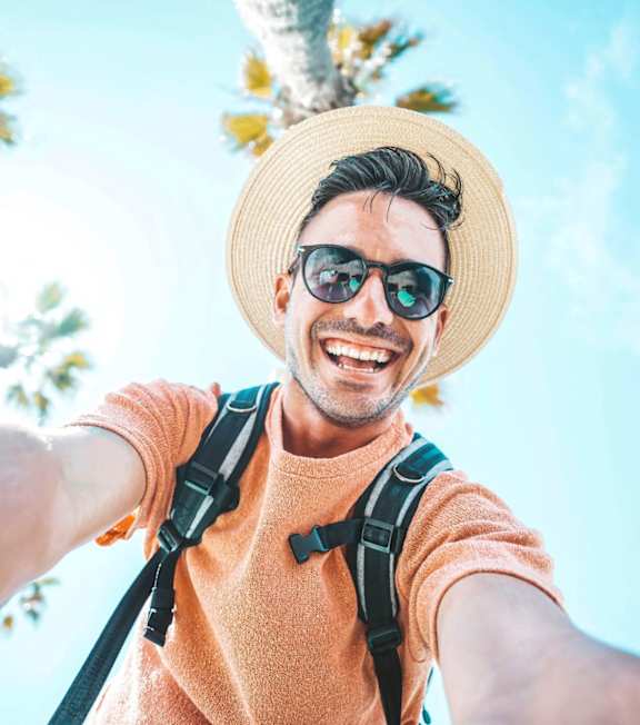 A man in a straw hat and sunglasses is taking a selfie with a backpack on. A man in a straw hat and sunglasses is taking a selfie with a backpack on. at Park Place Oviedo Apartments, Oviedo, FL