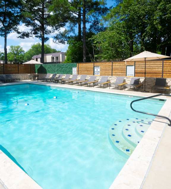 A person is floating in a pool with their eyes closed.at The Garden District Apartments, Germantown, TN