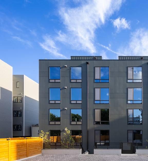 A modern building with a grey facade and large windows.