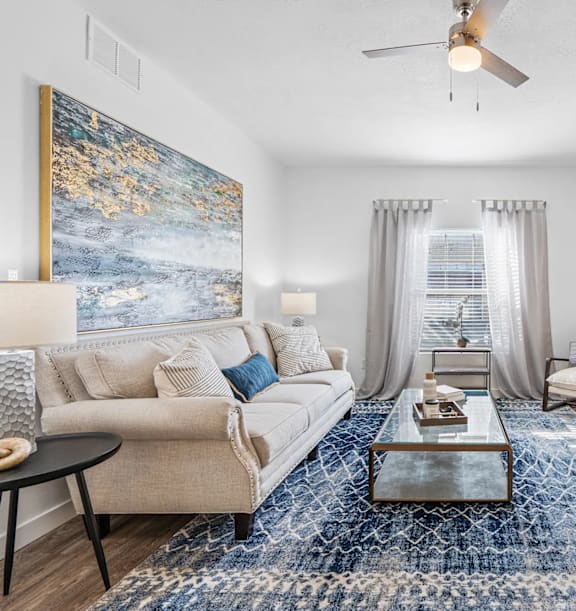 A living room with a large painting on the wall and a flat screen TV.