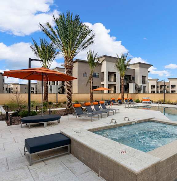 A BBQ grill is in the foreground of a residential area with palm trees.
