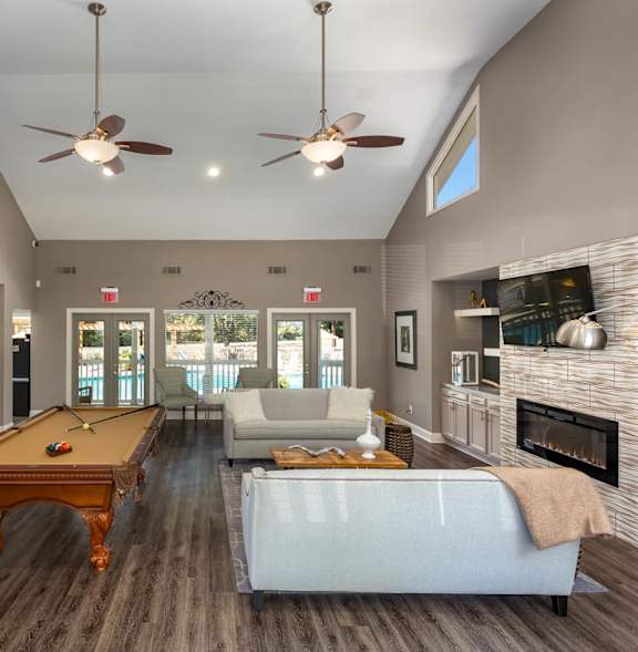 A pool table is in the middle of a room with a fireplace and a couch.