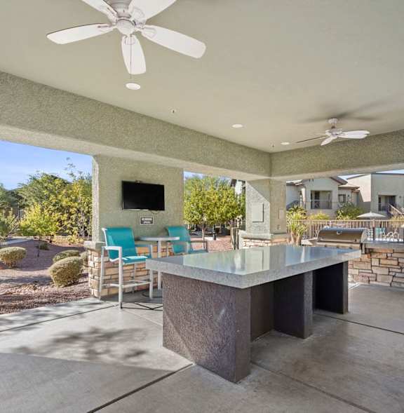A BBQ grill is in the foreground of a residential area with palm trees.