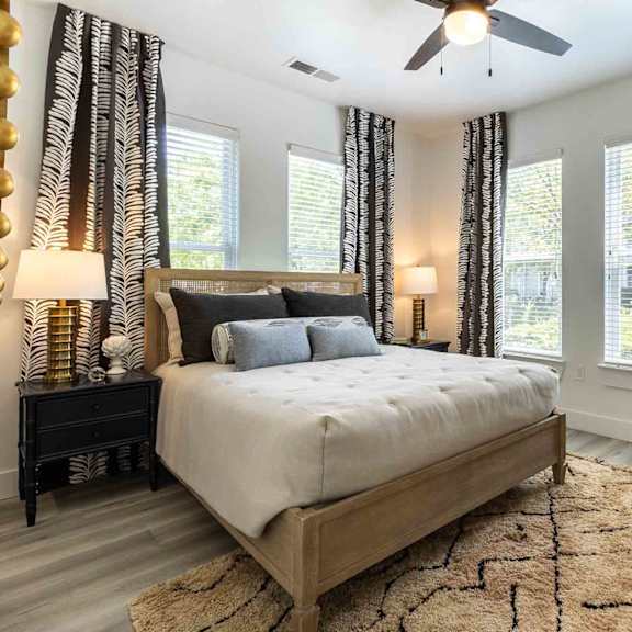 A bedroom with a bed, dresser, mirror, and a sign that says "Be Your Own HERO.".