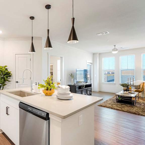 A modern kitchen with a large island and pendant lights.