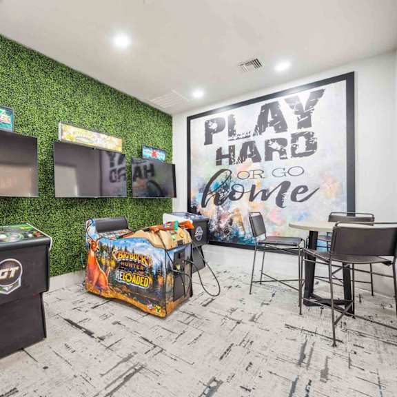 A room with a green wall and a sign that says "PLAY HARD OR GO HOME".