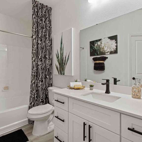 A white bathroom with a toilet, sink, and mirror.