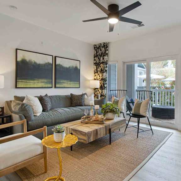 A living room with a grey couch, a yellow side table, and a painting on the wall.