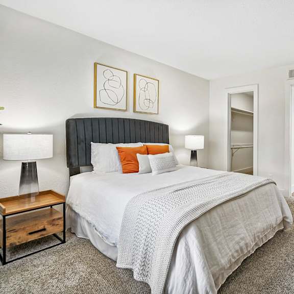 A bedroom with a large bed and a wooden dresser.