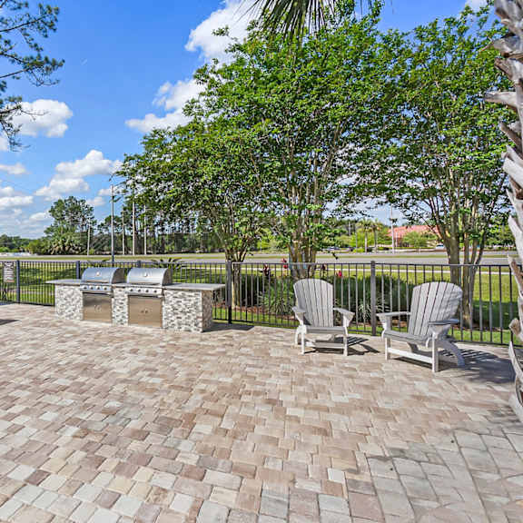 A patio with a table and chairs is surrounded by a fence.