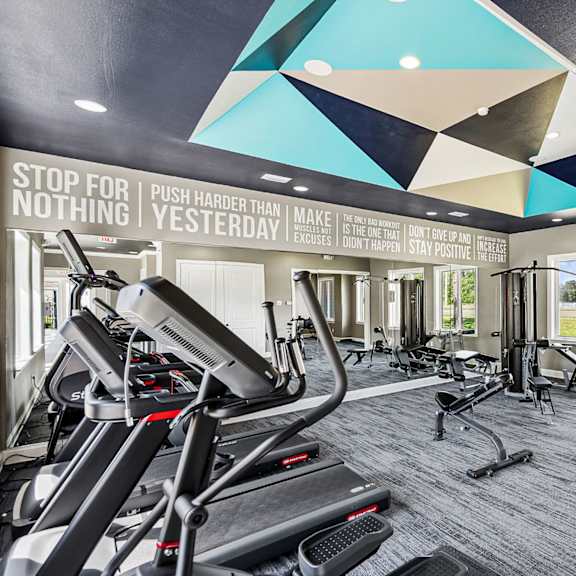 A gym with a motivational message on the wall.