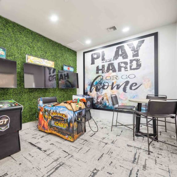 a game room with green turf wall and white brick flooring