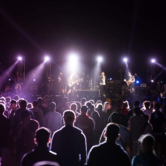 A concert is taking place with a band performing on stage.