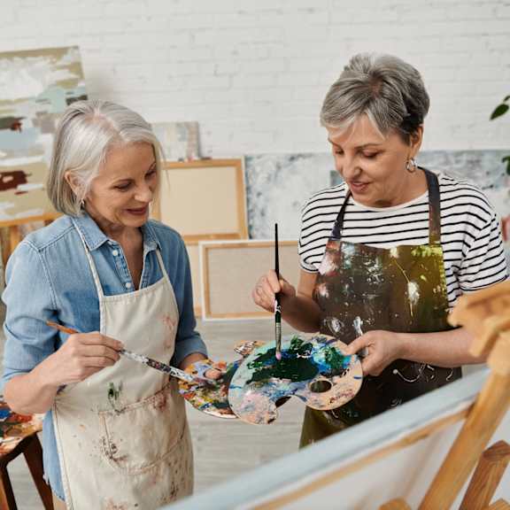Two women painting in an art studio.