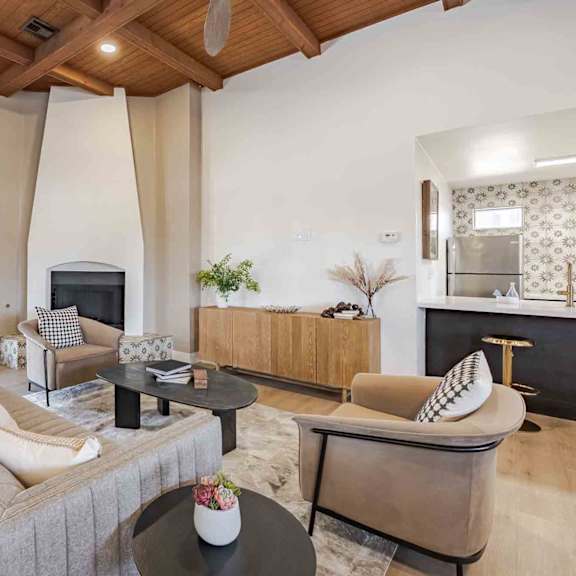 A living room with a grey sofa and a black coffee table.