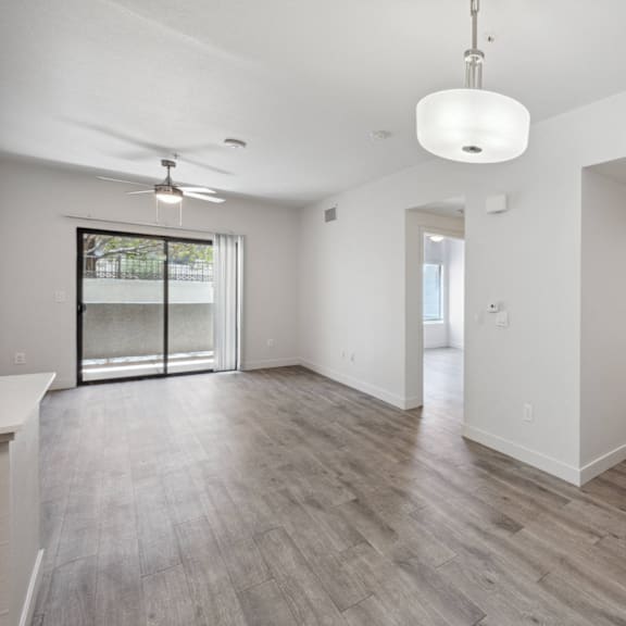 A spacious room with a ceiling fan and a large window.