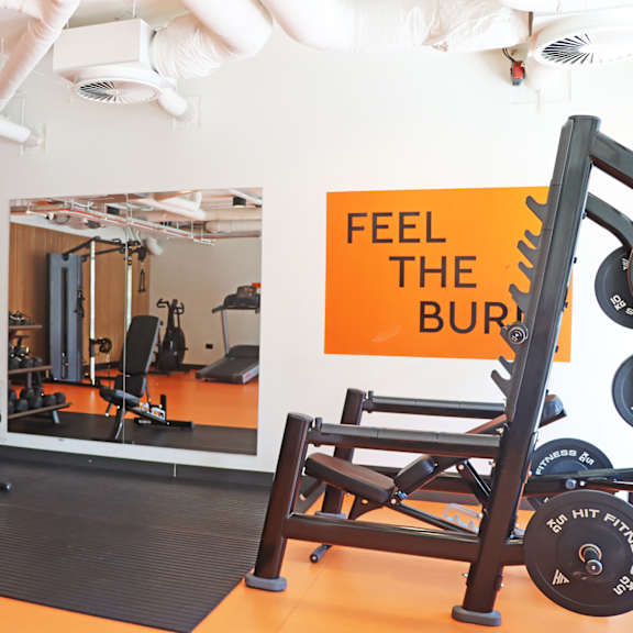 a gym with various exercise equipment on the floor and a window