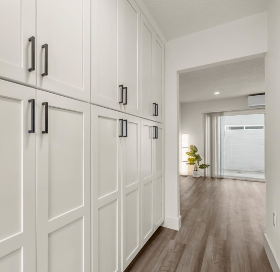 a row of white cabinets in a room with wood floors