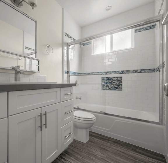 a bathroom with white cabinets and a shower and a toilet