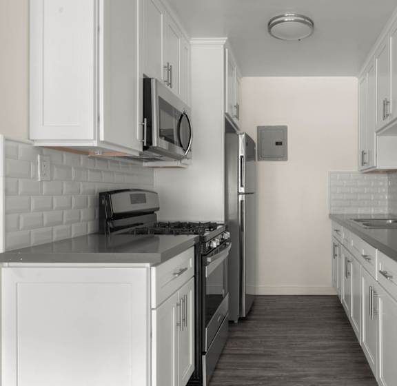 a kitchen with white cabinets and black counter tops