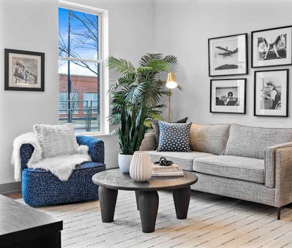 A modern living room with a white sofa, a white chair, and a large window.at The Ridge, Cincinnati, OH 45202
