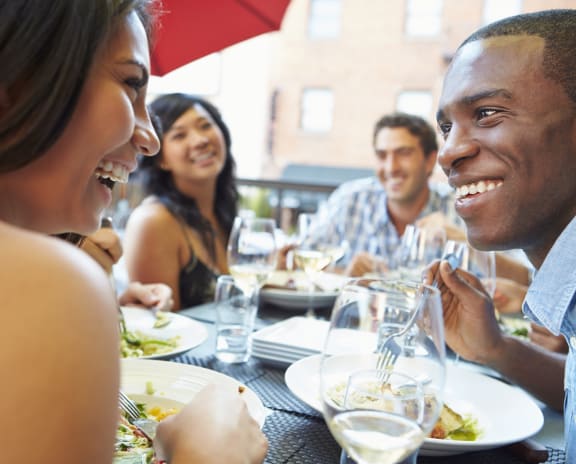 a group of people sitting at a table eating a meal