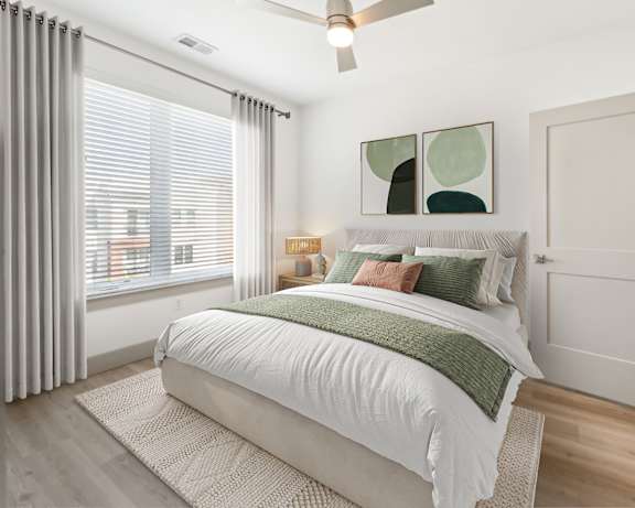 A bedroom with a large bed and a ceiling fan.