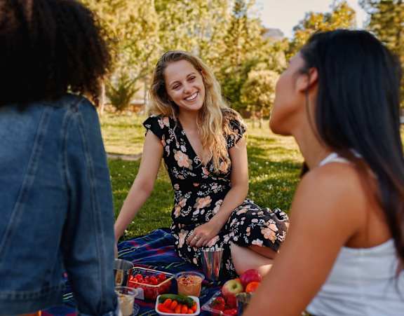 Three women having a picnic in a park.