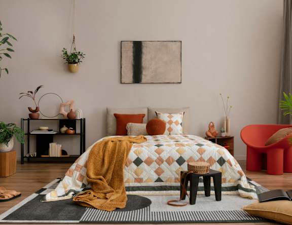 A modern living room with a white sofa, red pillows, and a wooden coffee table.