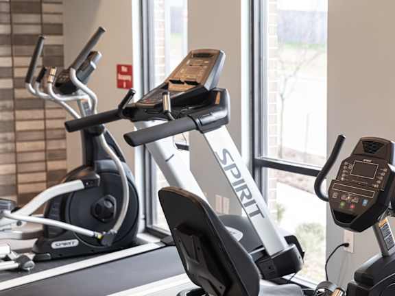 A Spiricom exercise bike is in a bright room with a window in the background.