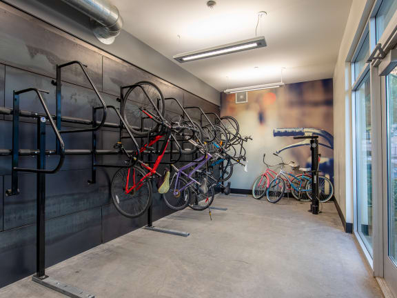 a bike rack with several bikes in a room with a large window