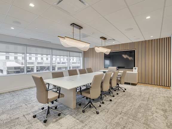 A conference room with a long table and chairs.