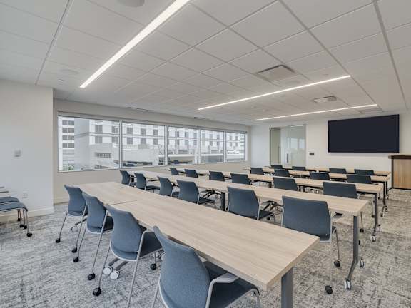 A conference room with a long table and chairs.